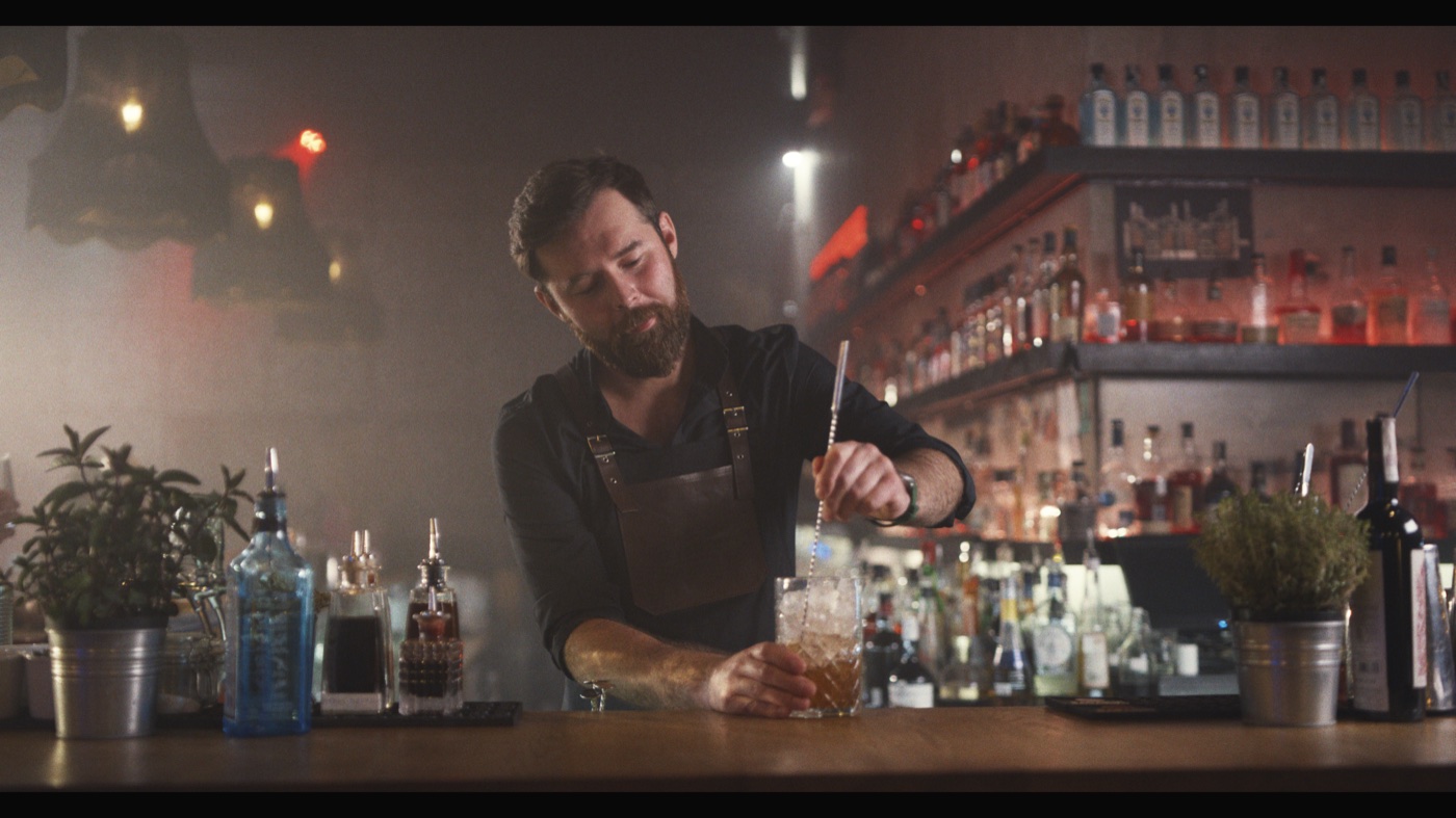 Source frame of a bartender mixing a drink before the Lacerta transform.